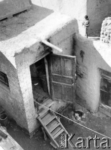 Uzbeckie domy - murowany budynek z drewnianymi schodkami-drabinką.