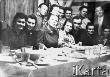 Grupa osób przy zastawionym stole.