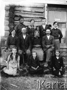 Polacy deportowani ze Stryjówki, pow. Zbaraż do posiołka Ozierki nad Tawdą; siedzą od lewej: Ludmiła Marczak, Maria Tracz, Anna Kołodziej, w drugim rzędzie od lewej: Karolina i Marian Marczakowie (M.Marczak, obywatel amerykański, zmarł w łagrze Krasnaja Gora), Aniela i Paweł Traczowie, w trzecim rzędzie stoją od lewej: Stanisław Korpyś z Nowego Sioła (dostał się do armii Andersa, zginął w czołgu pod Monte Cassino), Janina Marczak, Ryszard Kołodziej (zmarł w wieku 16 lat na zapalenie płuc), Paulina Kołodziej; w tle dom, w którym mieszkali podczas zsyłki Marczakowie i Kołodziejowie.