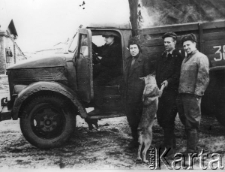 Samochód rozwożący więźniów do pracy, z prawej stoją dwaj enkawudziści; zdjęcie z lat 1954-55.