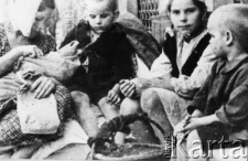 Troje dzieci ewakuowanych z armią Andersa do Persji, z lewej siedzi kobieta z niemowlęciem.