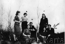 Grupa os&oacute;b w plenerze; podpis na odwrocie: "Po powrocie do Polski - odwiedziny koleg&oacute;w z osady".