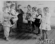 Grupa przedszkolaków podczas przedstawienia, na fotografii m.in. dzieci Wincentyny i Józefa Legieckich, deportowanych do ZSRR i pracujących w tajdze przy zbieraniu żywicy.