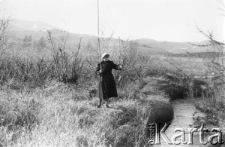 Młoda kobieta łowiąca ryby na wędkę.