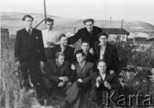 Grupa mężczyzn na tle budynków osiedla.