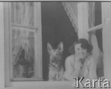 Anna Wnuk, żona sędziego Kazimierza Wnuka zamordowanego w Starobielsku, wygląda przez okno ze swoim psem.