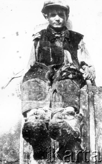 Chłopiec w zniszczonym ubraniu, prawdopodobnie dziecko z grupy, która opuściła ZSRR wraz z armią Andersa.