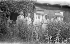 Grupa os&oacute;b w ogrodzie przed domem, pierwszy z lewej stoi Stanisław Owsianny kpt. WP, służący w sztabie w Częstochowie, zamordowany w Katyniu.