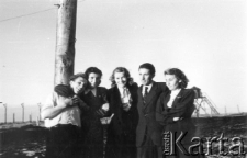 Polacy zwolnieni z łagrów, stoją od lewej: mężczyzna NN, Klara Kunachowicz, Barbara Dudycz, Edmund Weber, Hanna Grzywacz, w tle zasieki z drutu i budka strażnicza.