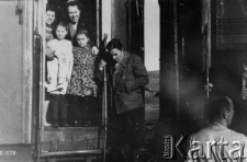 Polacy wracający z zesłania w ZSRR do kraju, w drzwiach kolejowego wagonu stoją: Maria Michalczuk i Janina Durlik, niżej stoi Leopold Ćwikla, nazwiska dzieci nieznane.